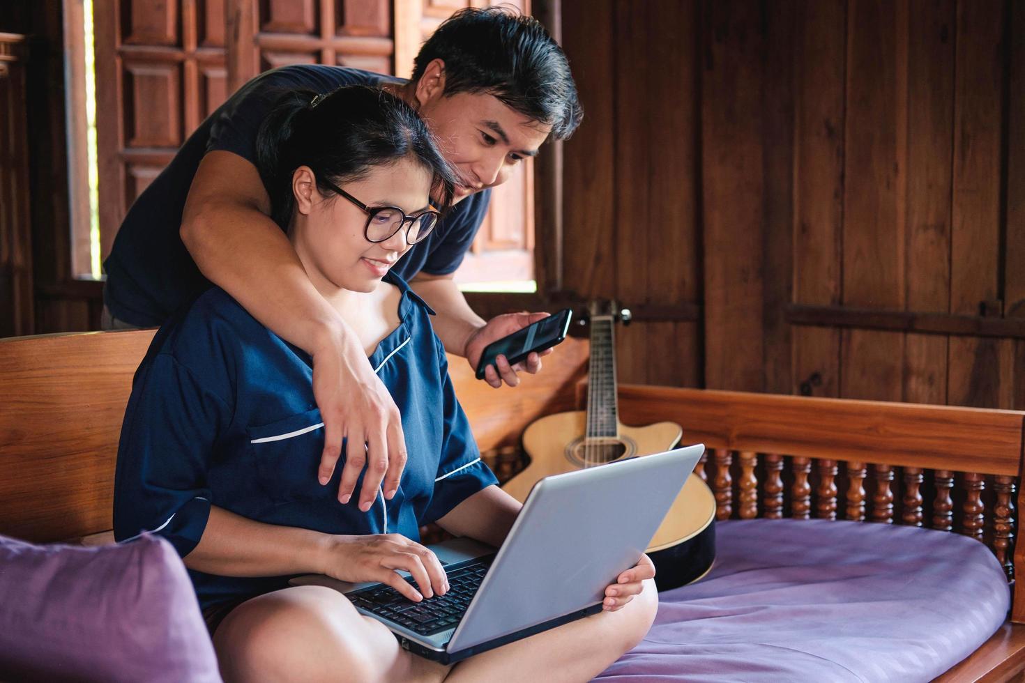 young Couple Using Laptop On Desk At Home and think photo