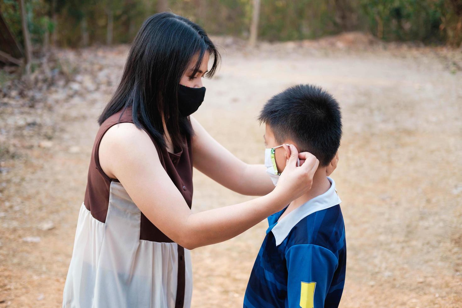 The mother is wearing a mask to protect her son from the covid virus photo