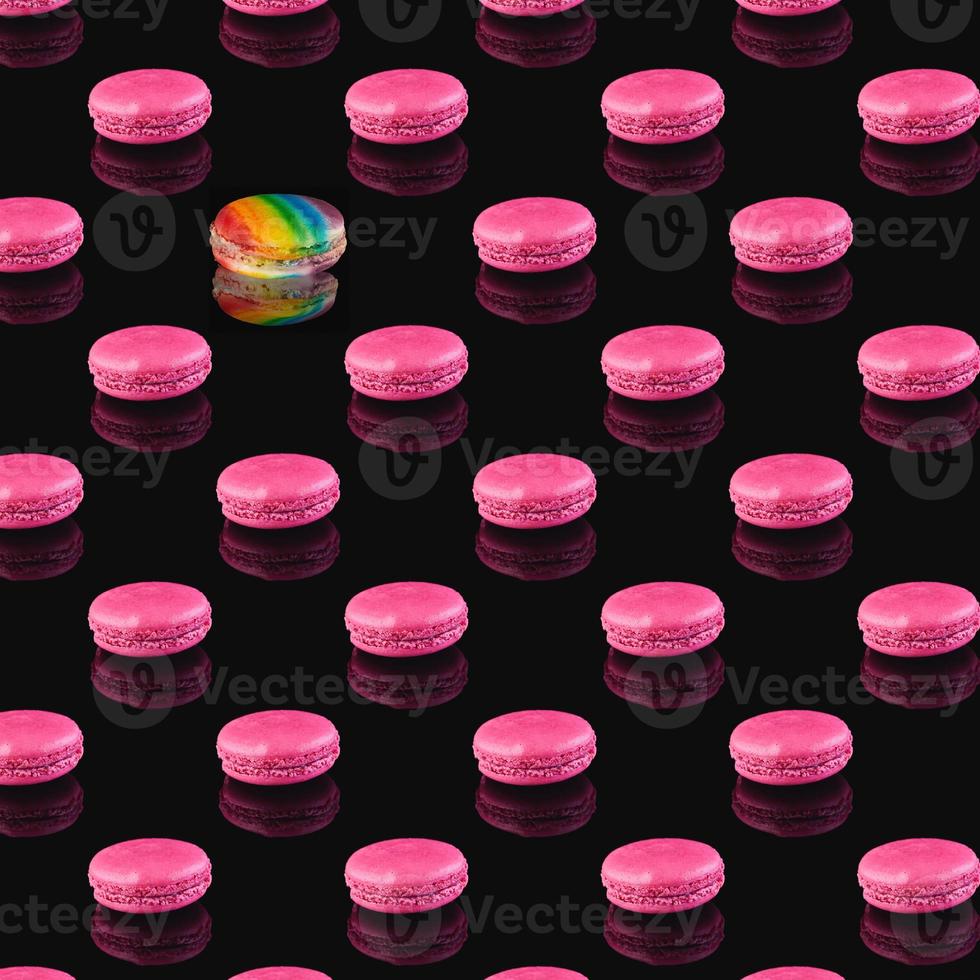 Patrón de macarons rosados con una reflexión sobre un fondo negro foto