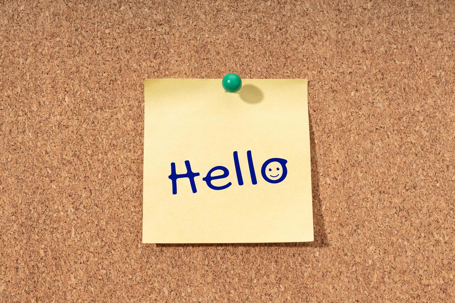 Hello word on yellow note on cork board photo