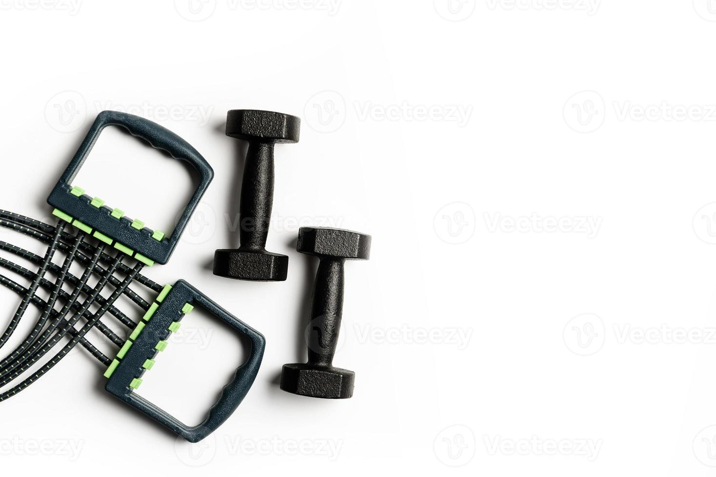 Expander and two dumbbells isolated on a white background photo