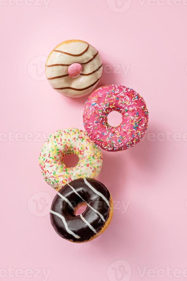 Glazed donuts levitating on a pink background photo