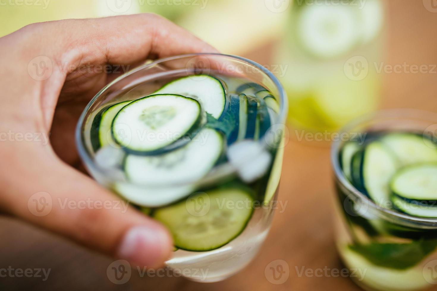 sosteniendo un vaso con agua desintoxicante infundida foto