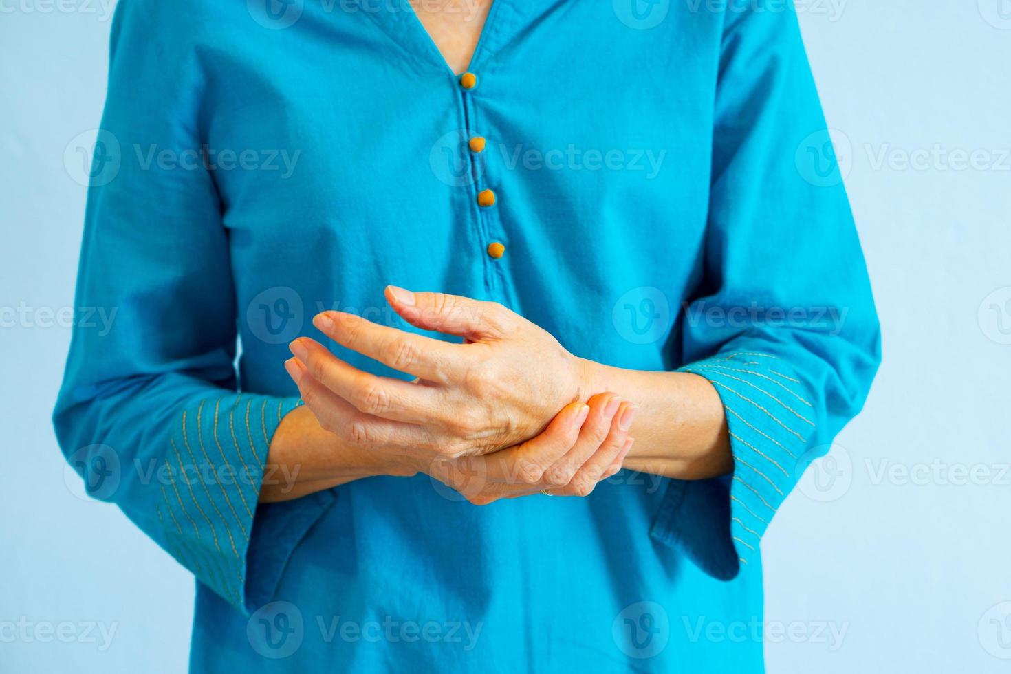 Senior woman getting wrist joint pain from rheumatoid arthritis photo