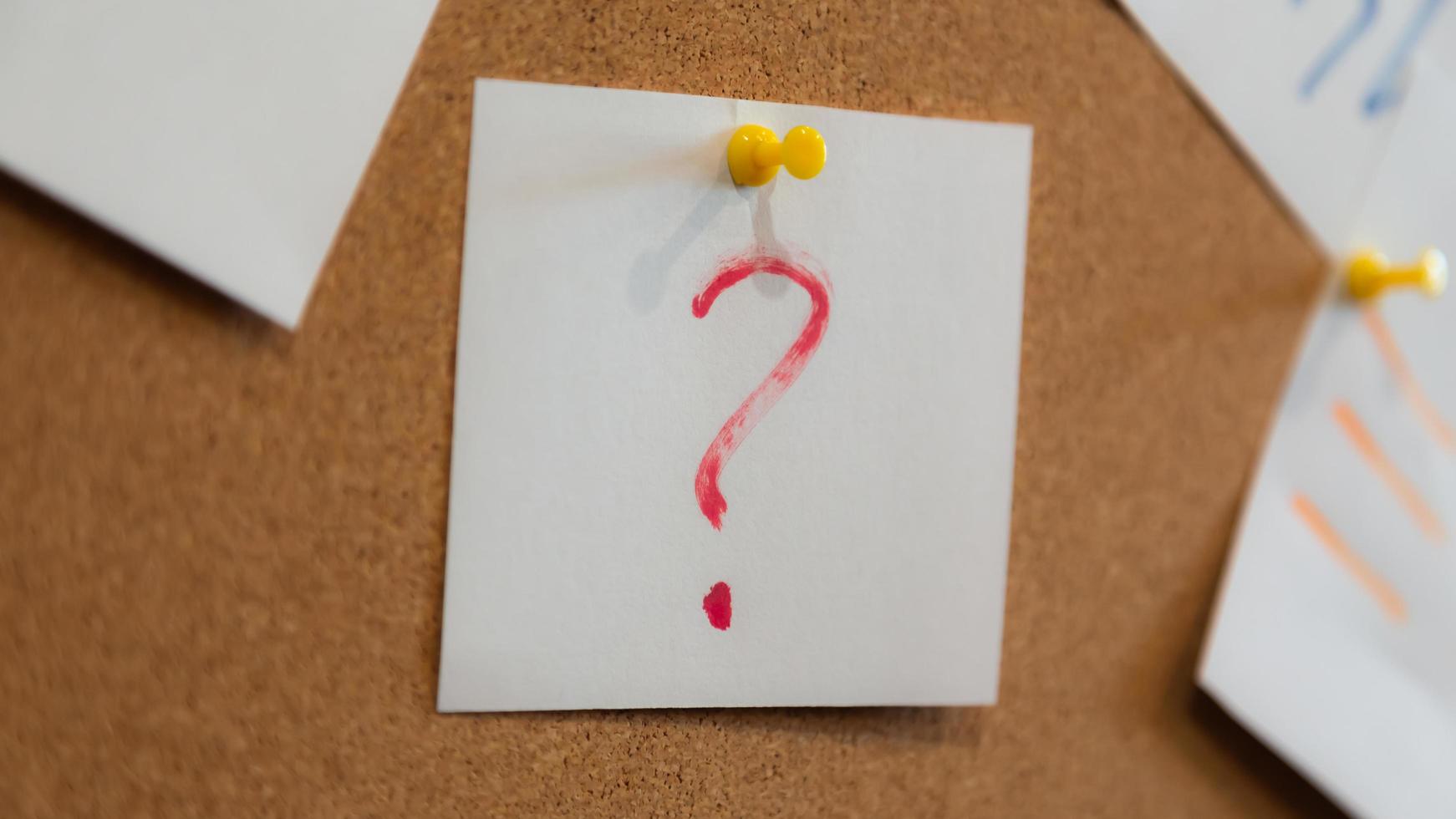 Red question mark on a piece of paper and many papers photo