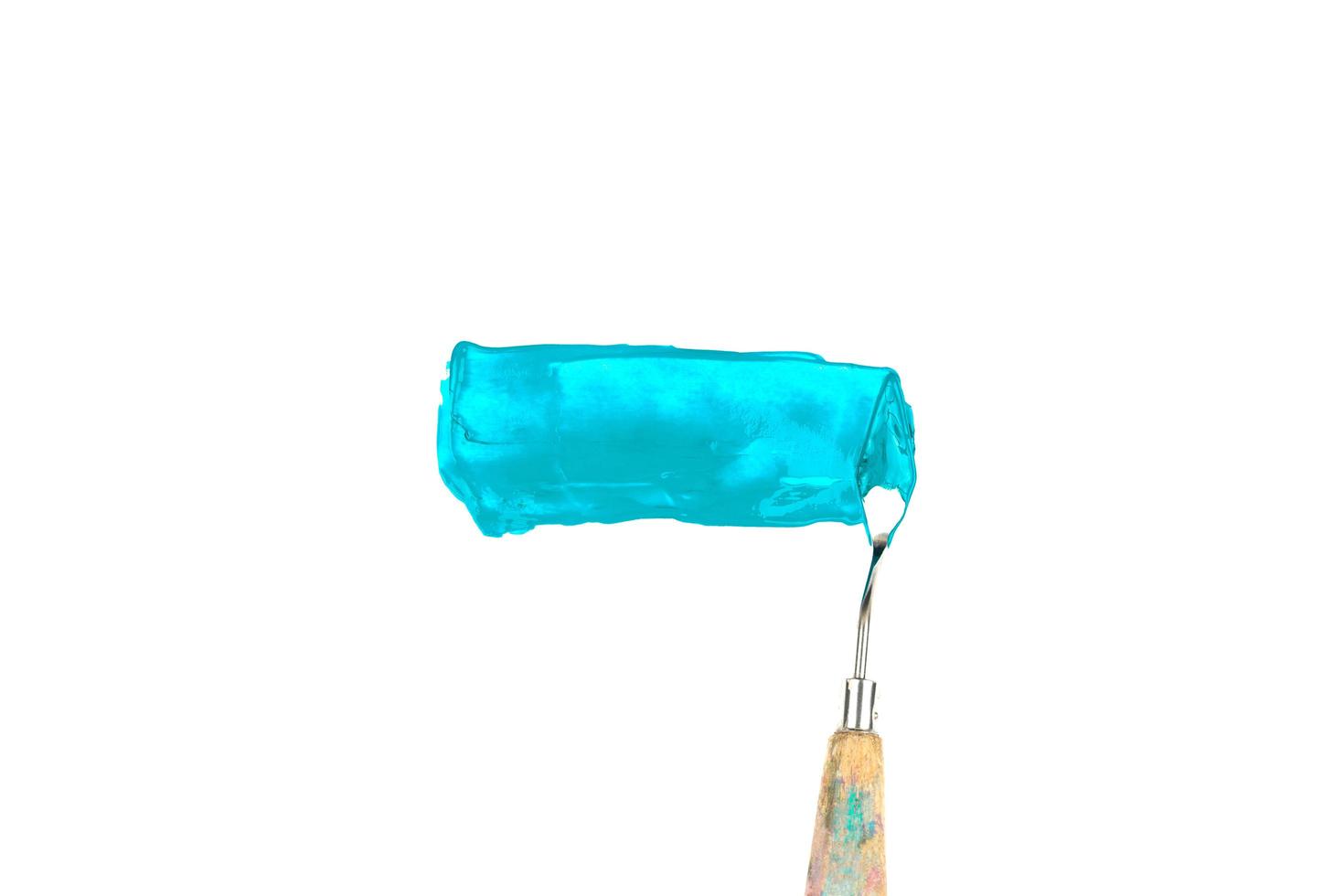Una espátula de pintura aislada sobre un fondo blanco pintura azul verde azulado foto