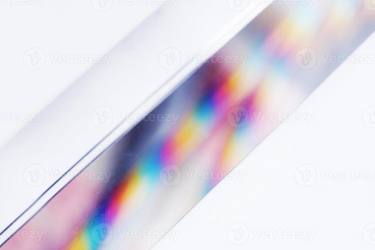 An amazing and beautiful macro with space and clearness about a crystal prism where it can be seen a rainbow on white background photo