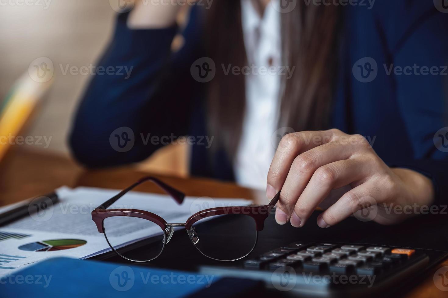 The accountant or accountant holds glasses for resting his eyes from the balance sheet photo