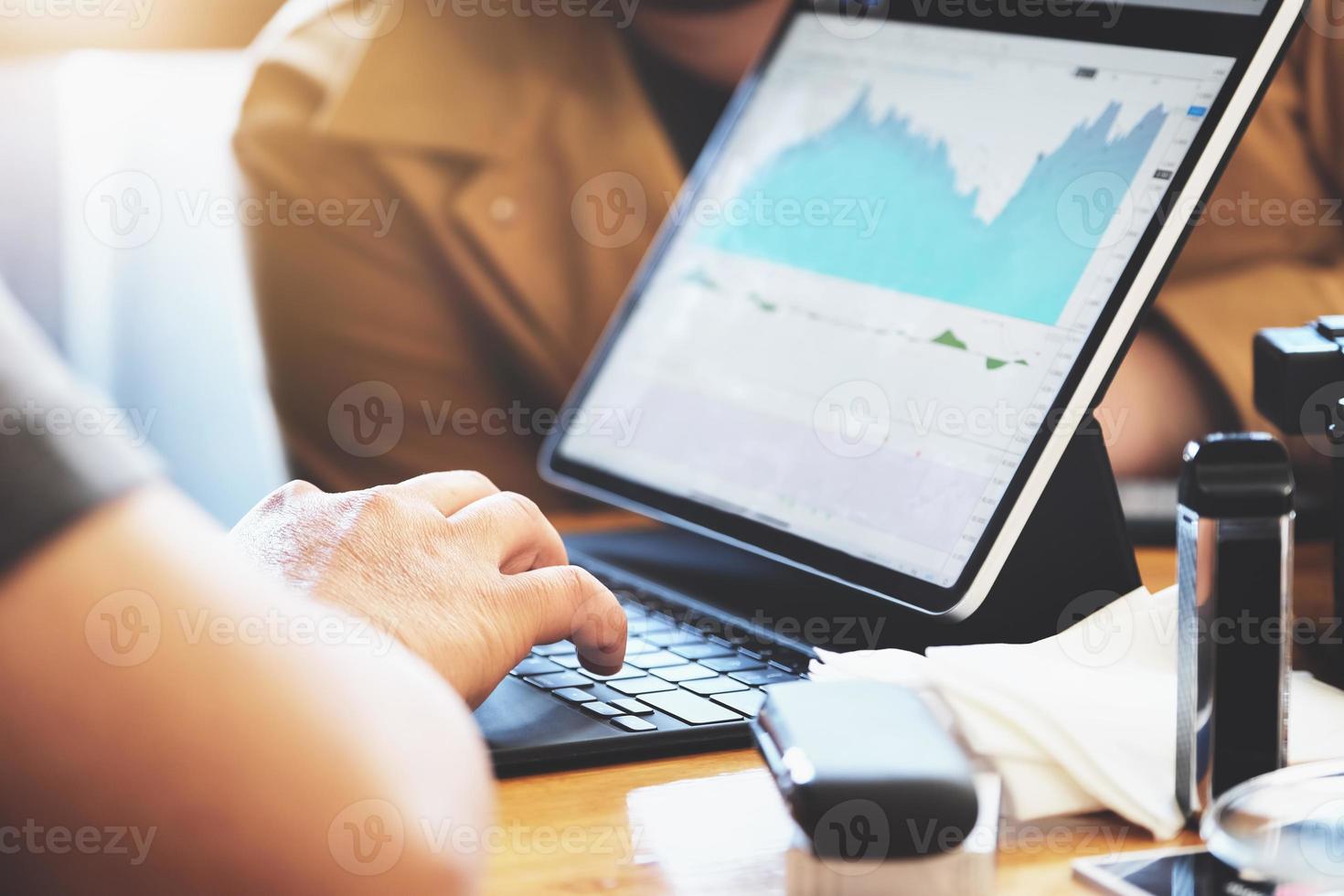 Focus hands of a speculator who is using a tablet to trade stocks to make a profit on his own port photo