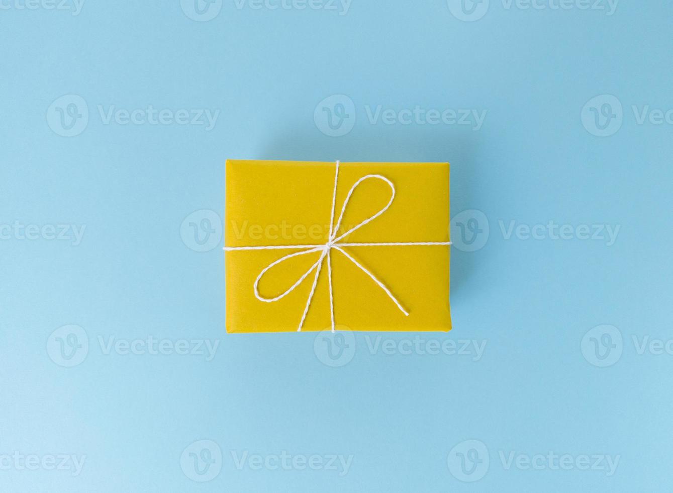 Yellow gift box on a blue background photo