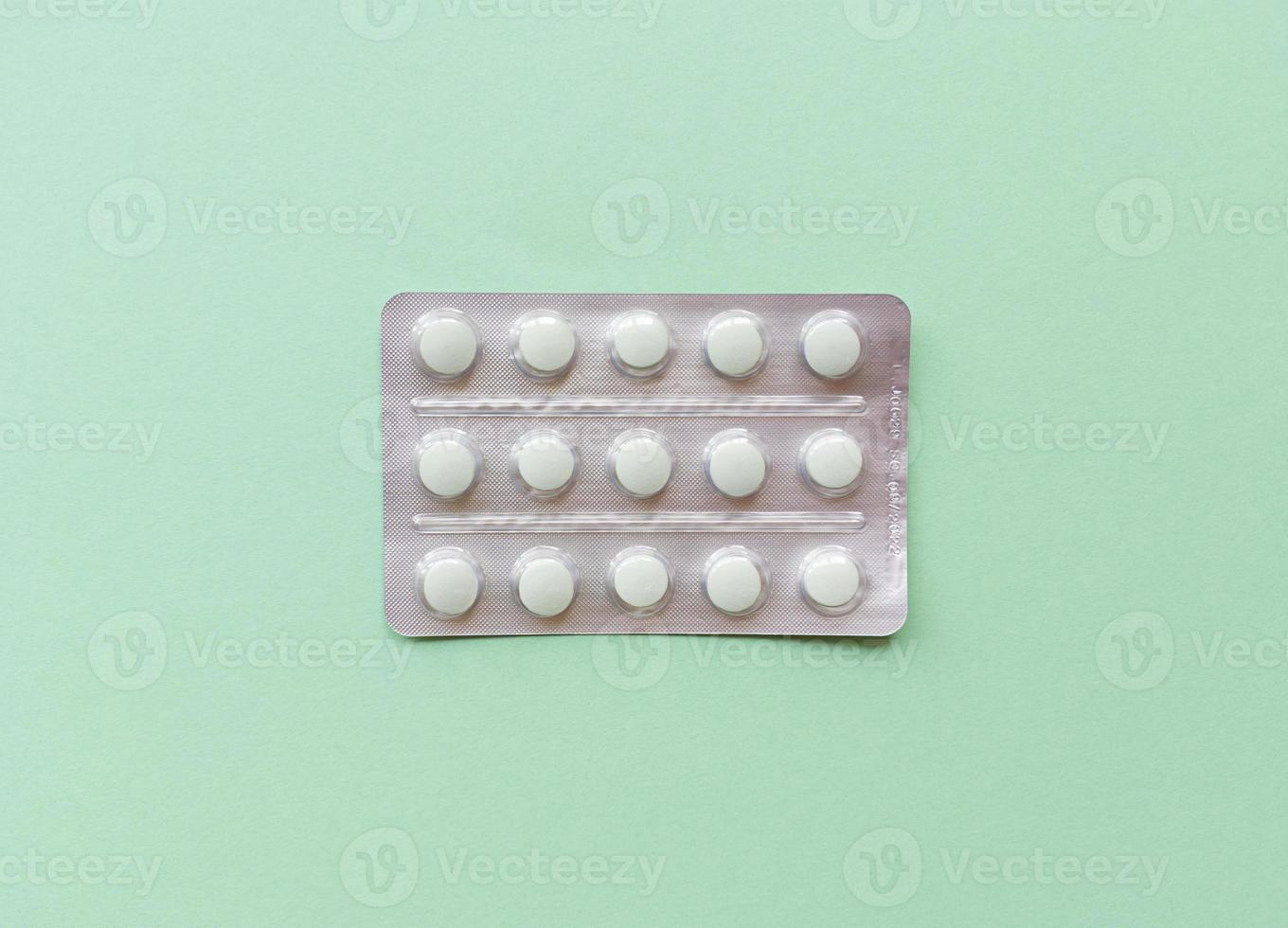 A blister of pills in the middle green background Monochrome simple flat lay with pastel texture Medical concept Stock photo