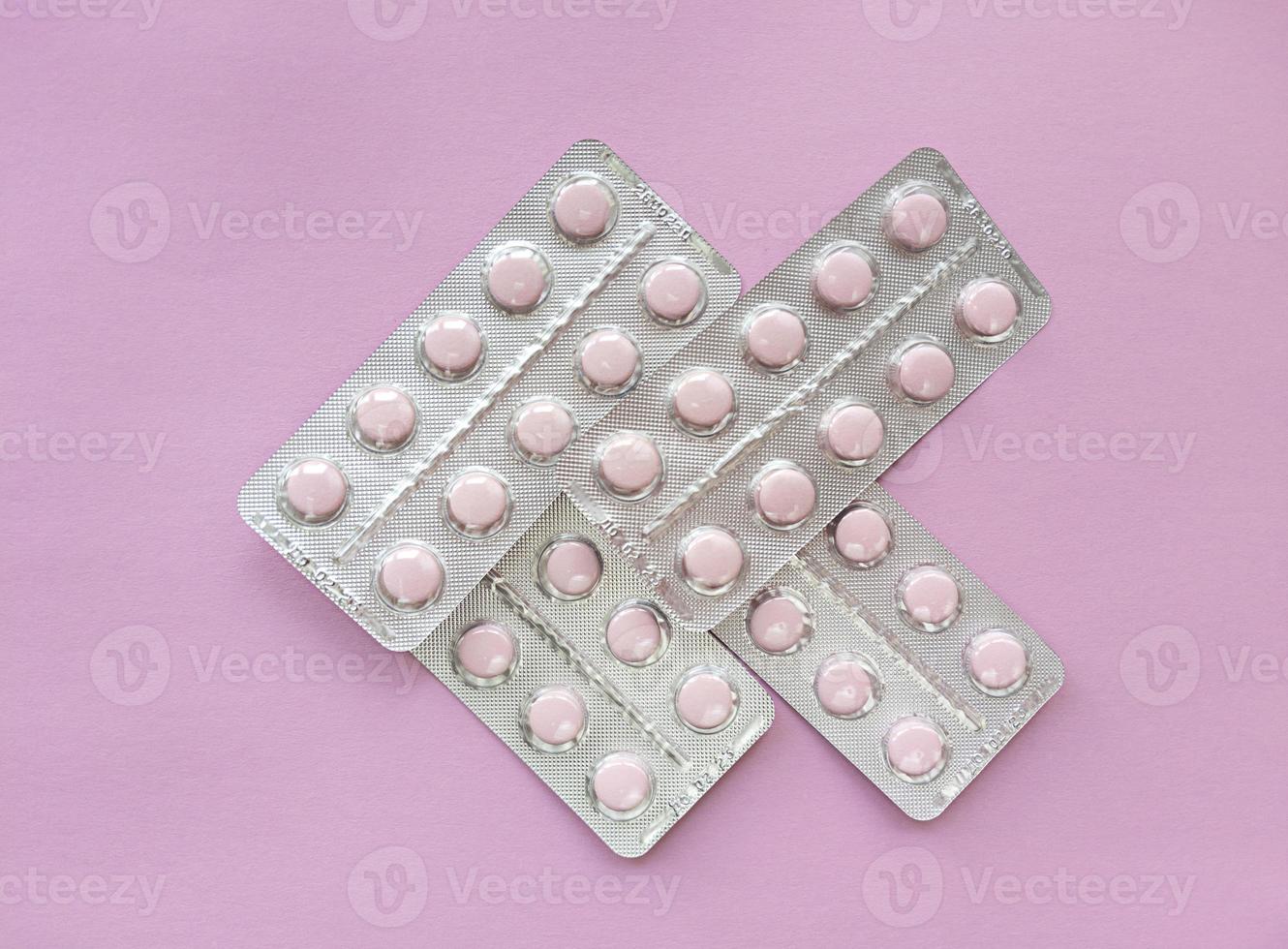 Blisters of soft pink pills on pink background Monochrome simple flat lay with pastel texture Medical concept Stock photo