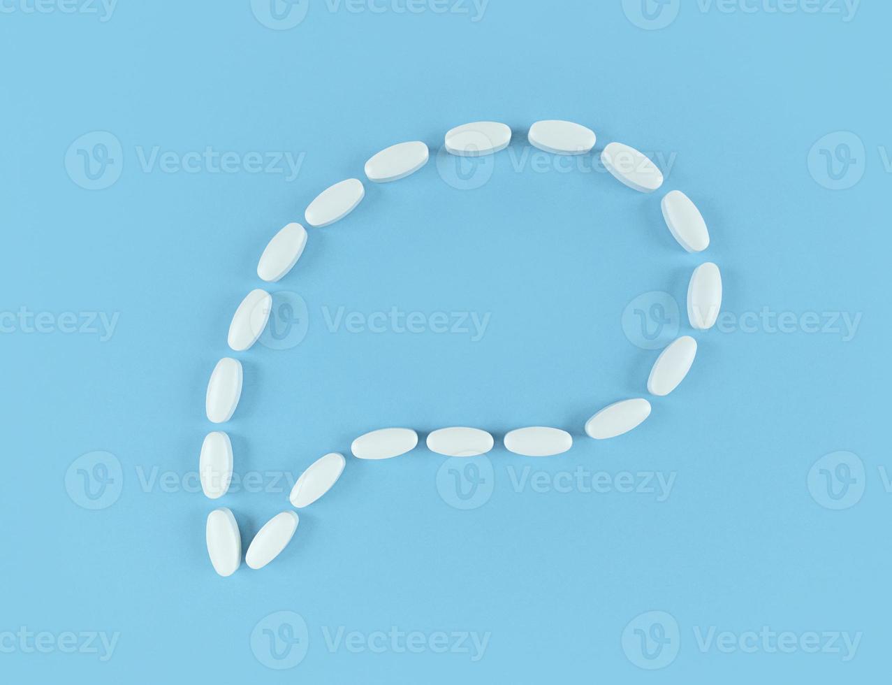 Speech bubble made from white tablets on blue backdrop with copy space photo