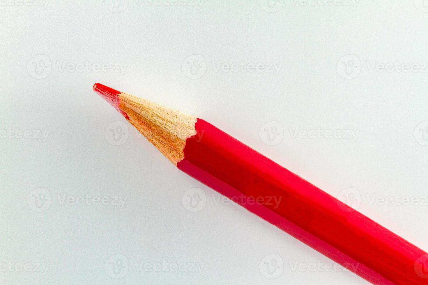 Red color pencil on white color paper arranged diagonally photo