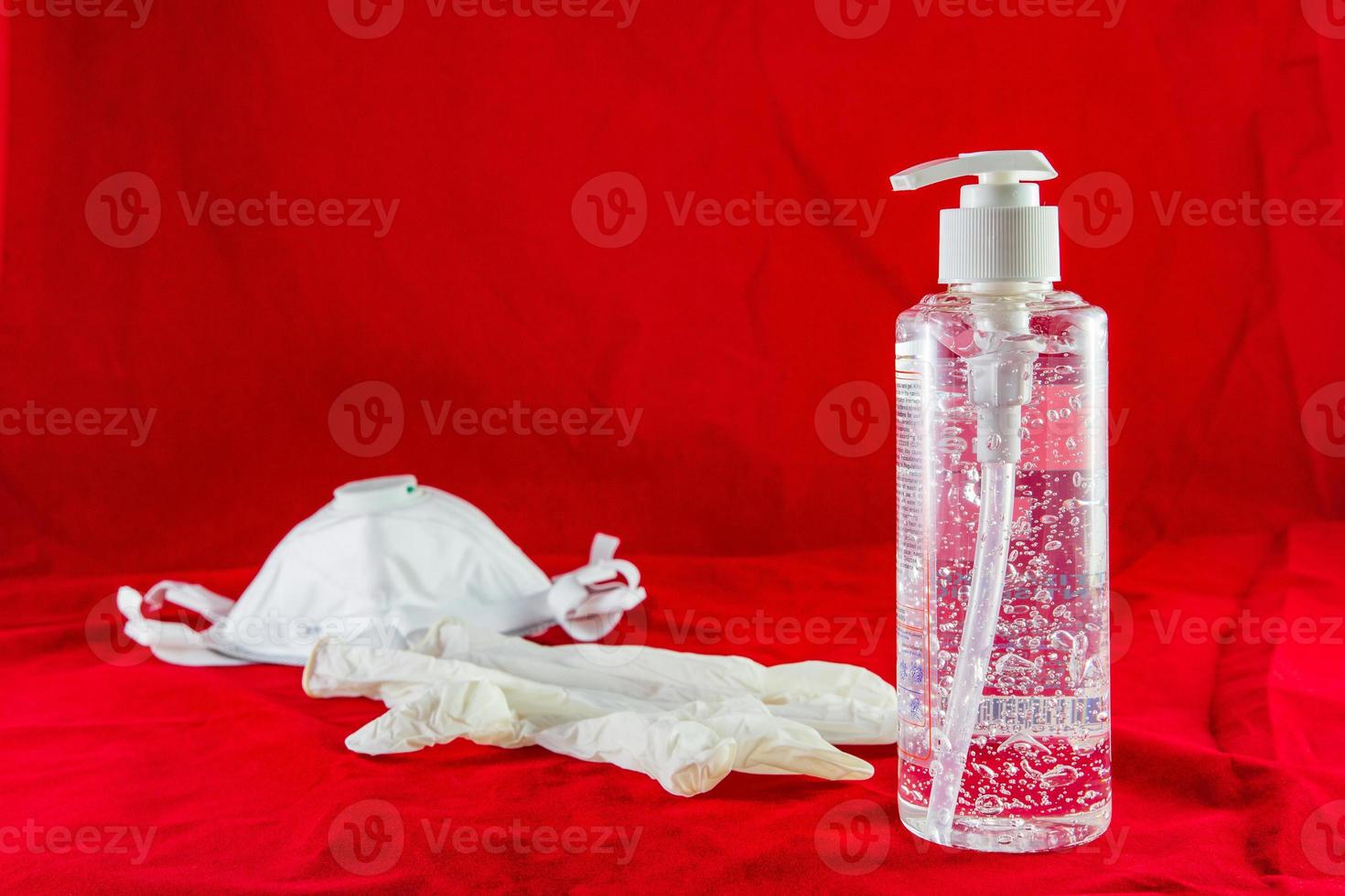 gel desinfectante guantes de látex blanco y máscara en concepto de protección roja contra el virus de la contaminación, la gripe y el coronavirus foto