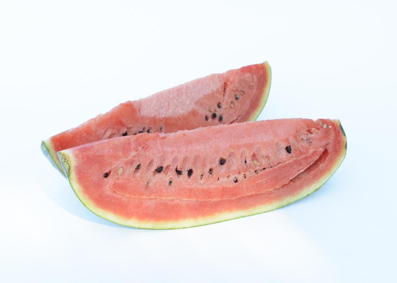 Frutas de sandía de dos piezas sobre fondos blancos. foto