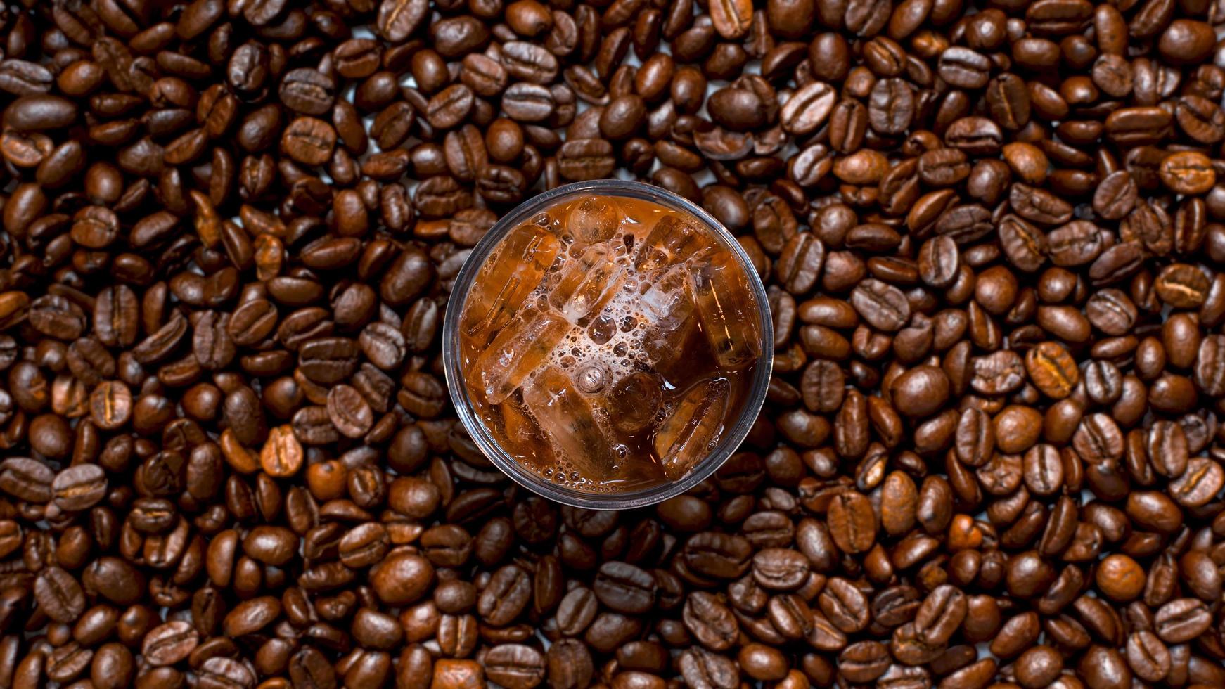 Top view of iced coffee in pile of coffee beans photo