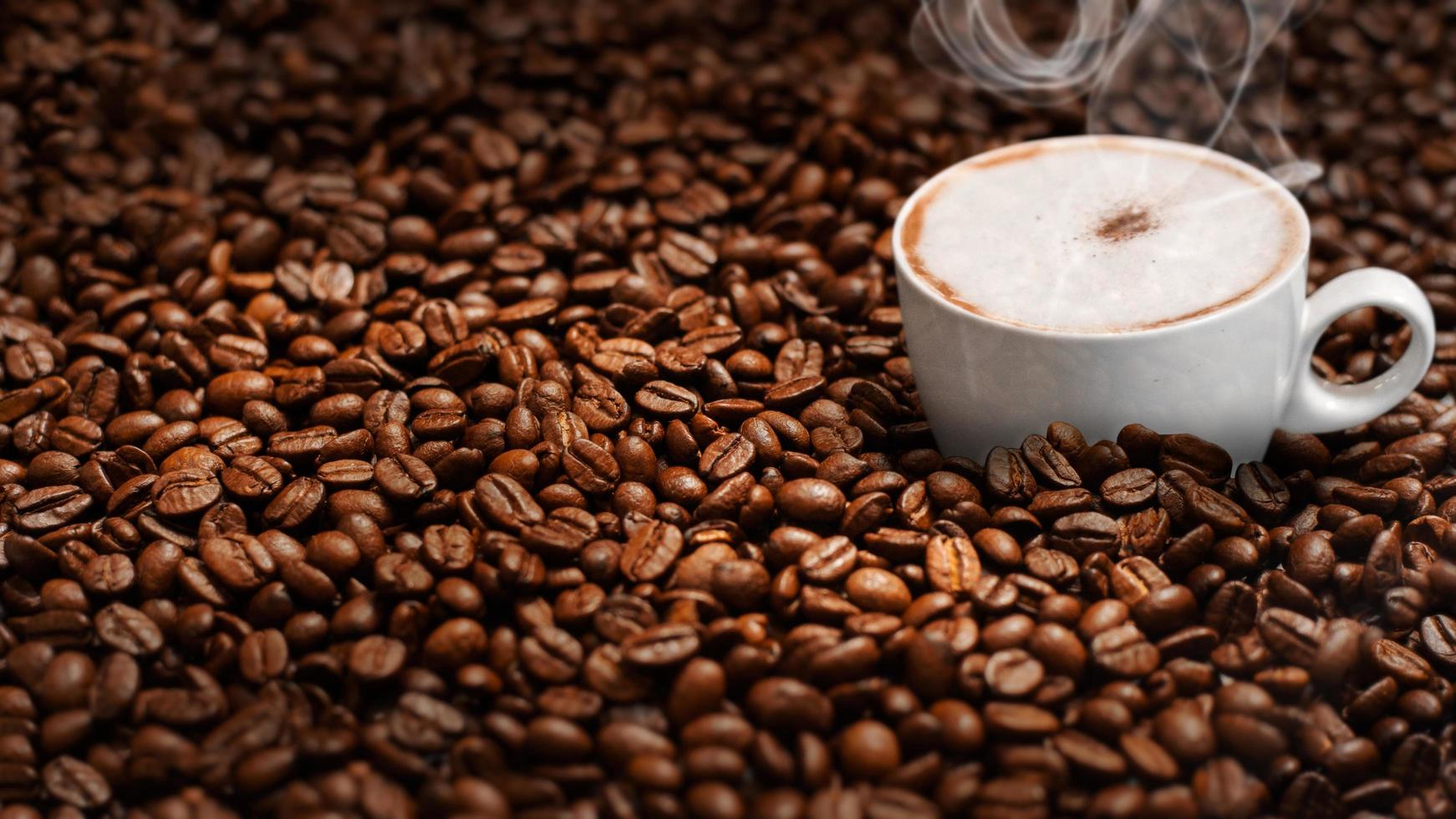 Cup of coffee in pile of coffee beans photo