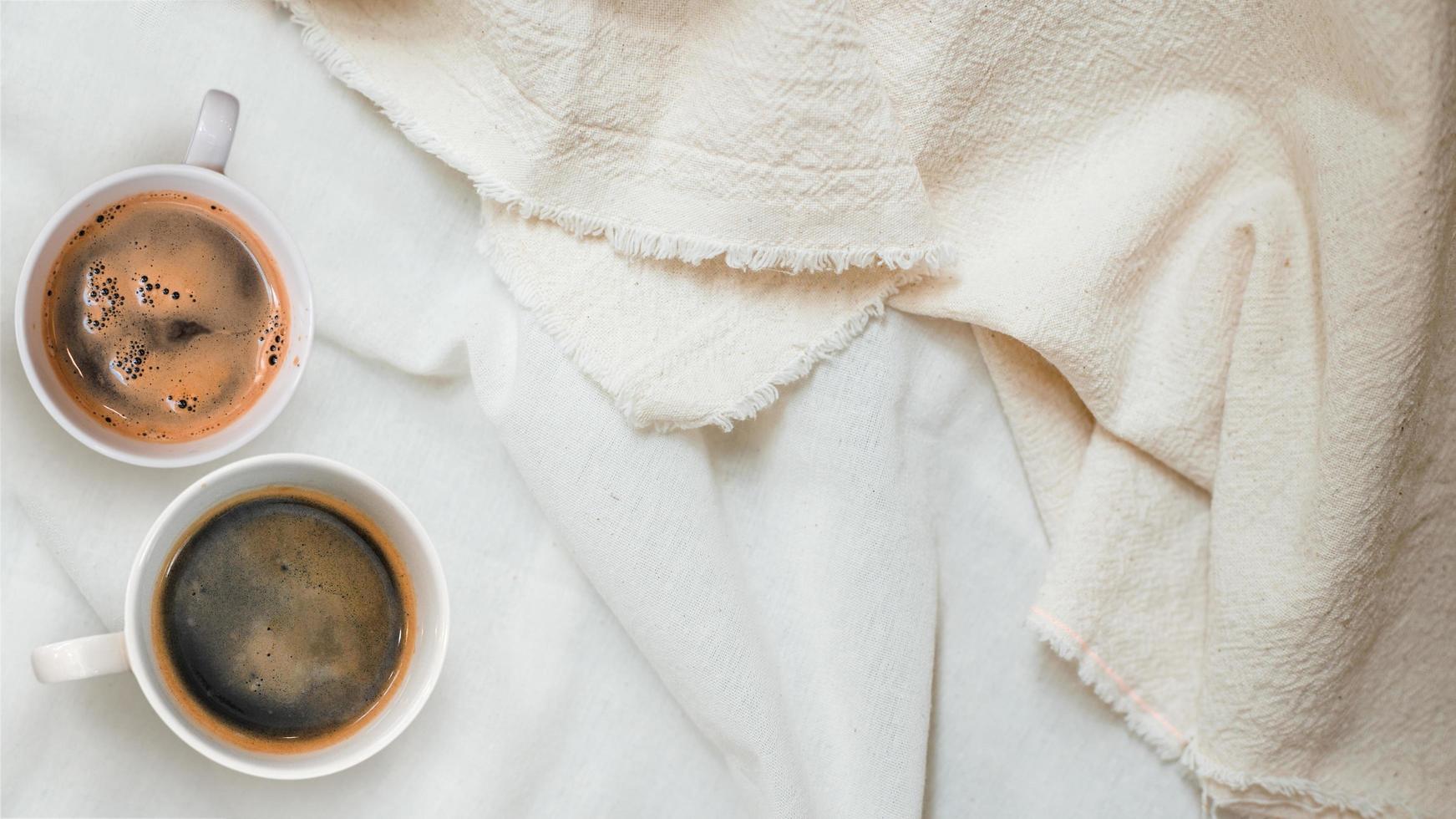 Top view of cups of coffee on a white tablecloth photo