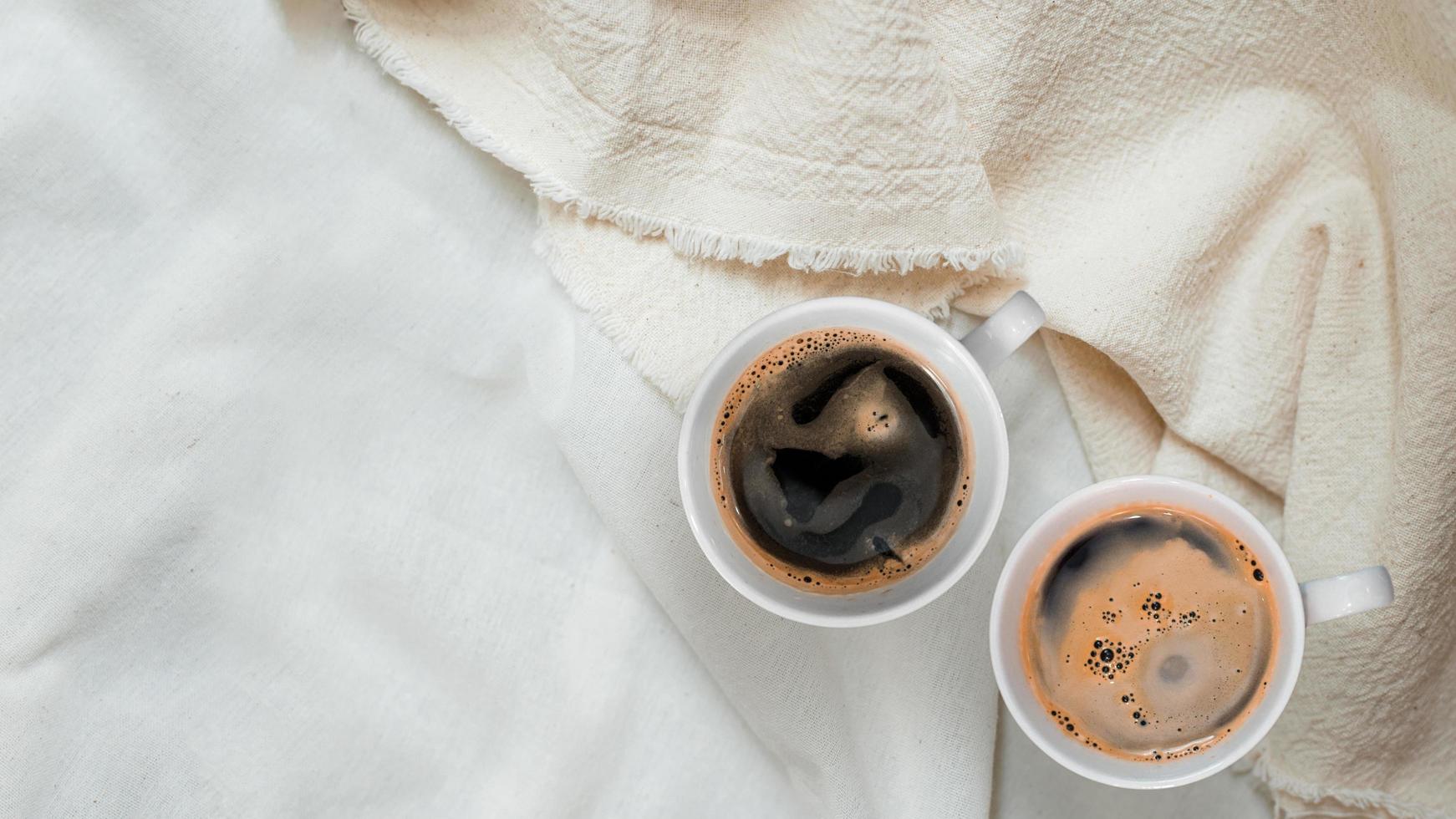 Top view of cup of coffee on a white tablecloth photo