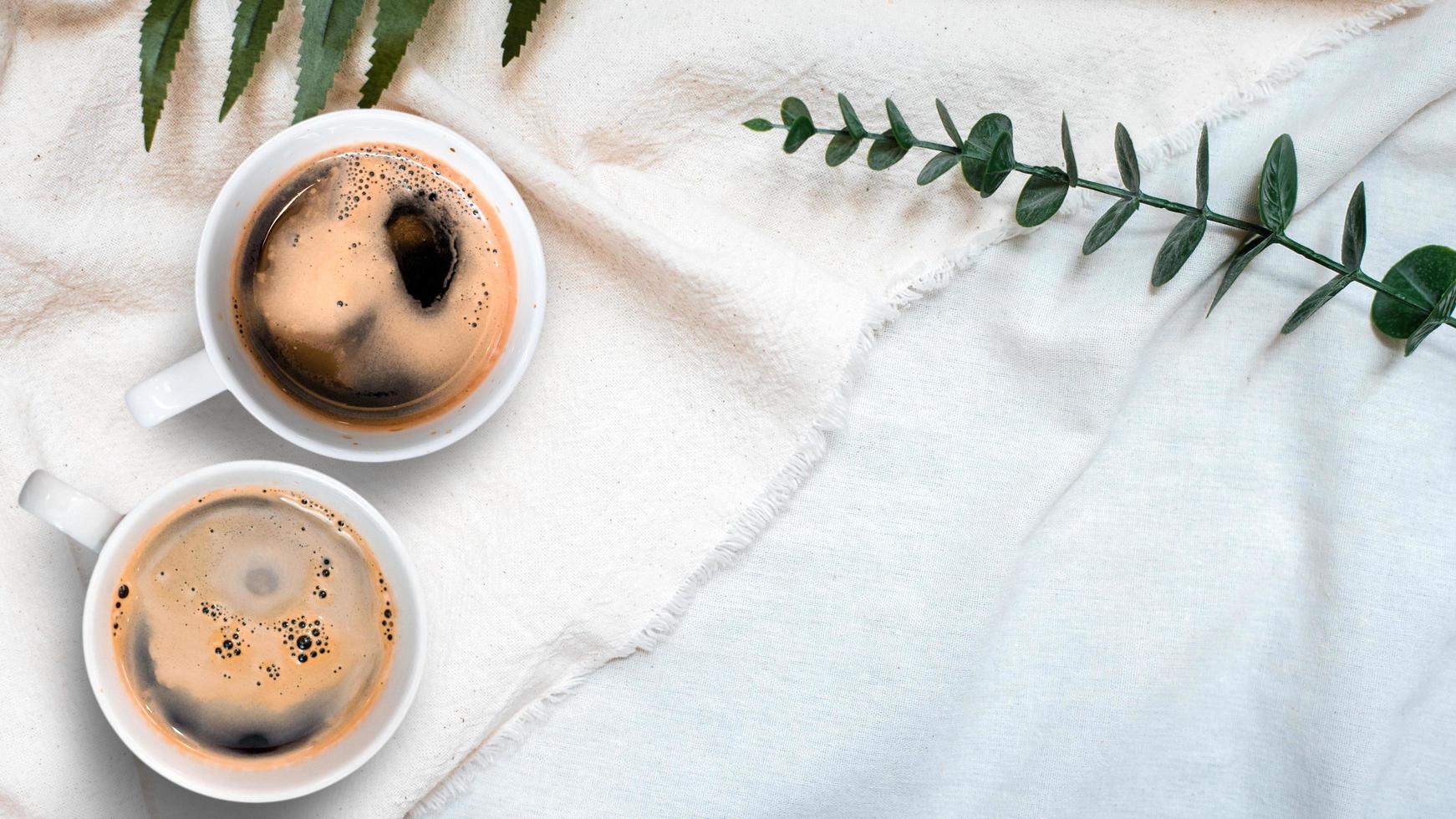 Top view of cup of coffee on a white tablecloth photo