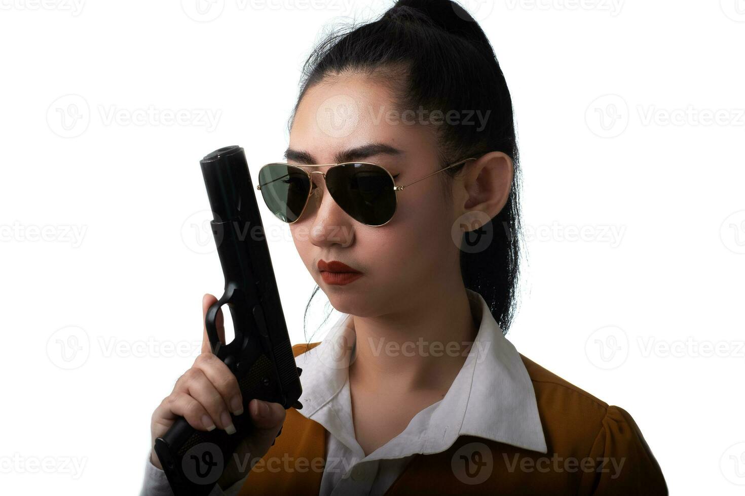 Retrato hermosa mujer asiática vistiendo un traje amarillo con una mano sosteniendo la pistola en el fondo blanco. foto