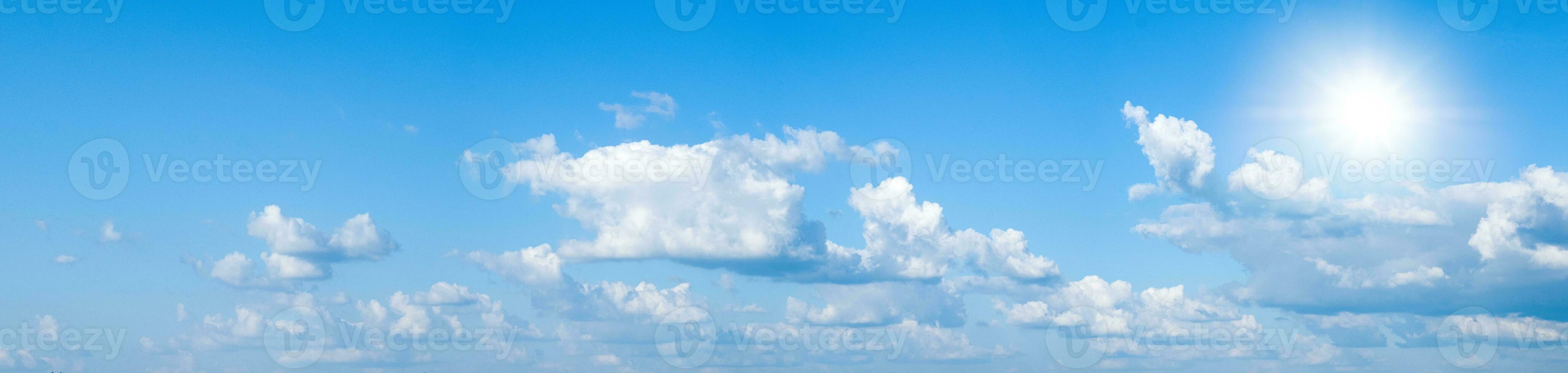 Beautiful clear blue sky with white clouds and sun photo