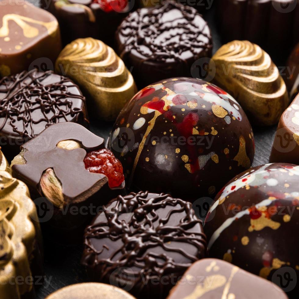 Luxury chocolate pieces on the black background top view photo