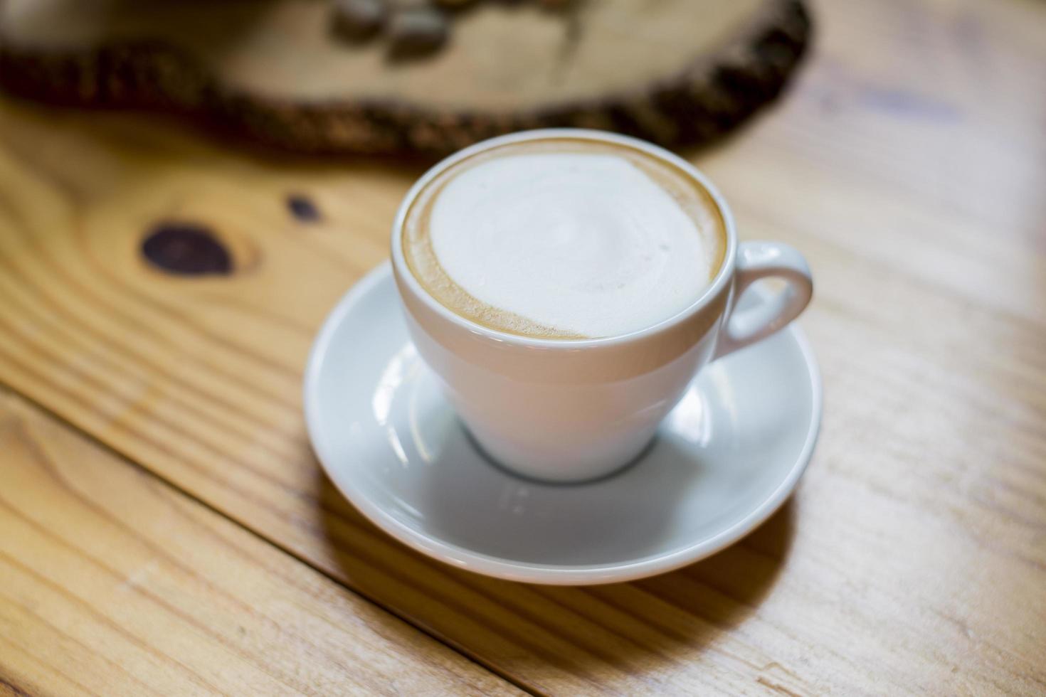 una taza de capuchino caliente en la mesa de madera foto