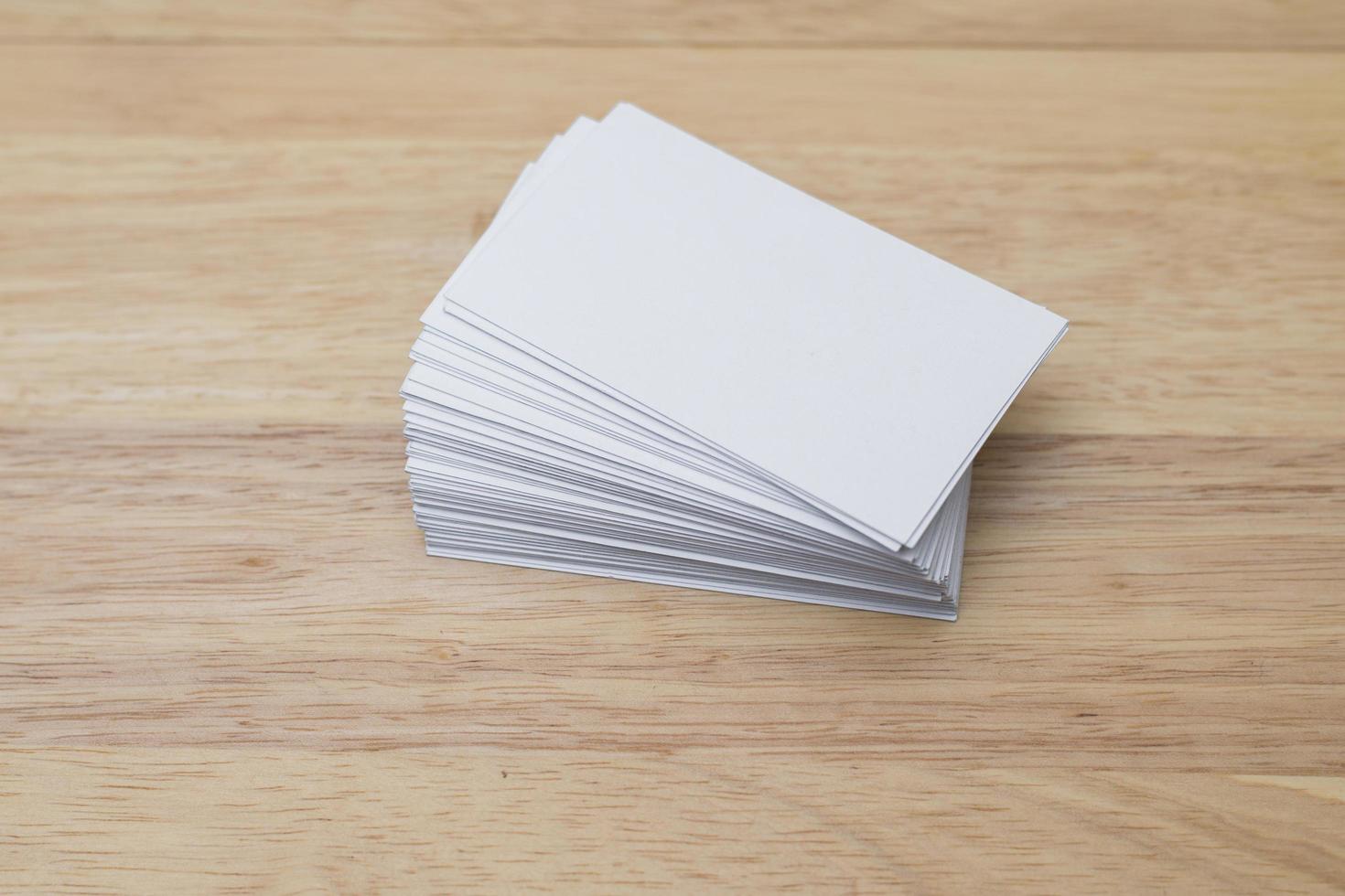 Blank business cards stack up on wooden background photo