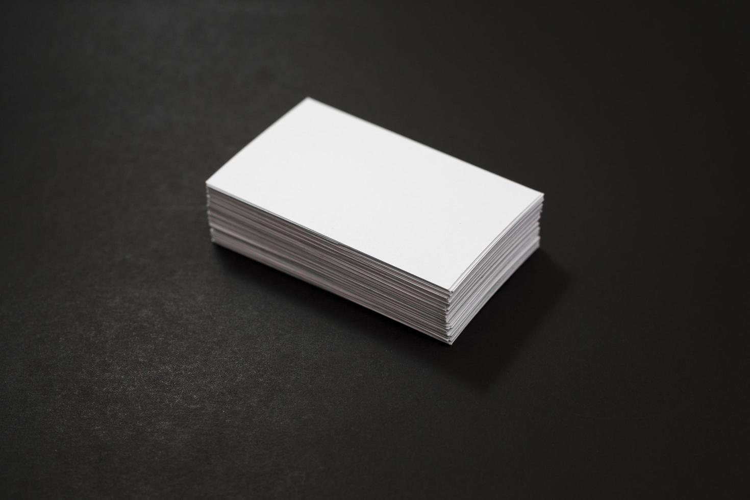 Blank business cards stack up on black background photo