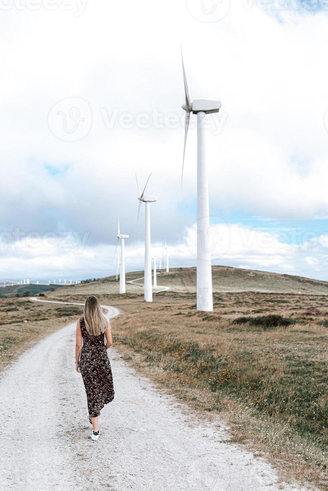 mujer caminando por un parque de turbinas eólicas foto