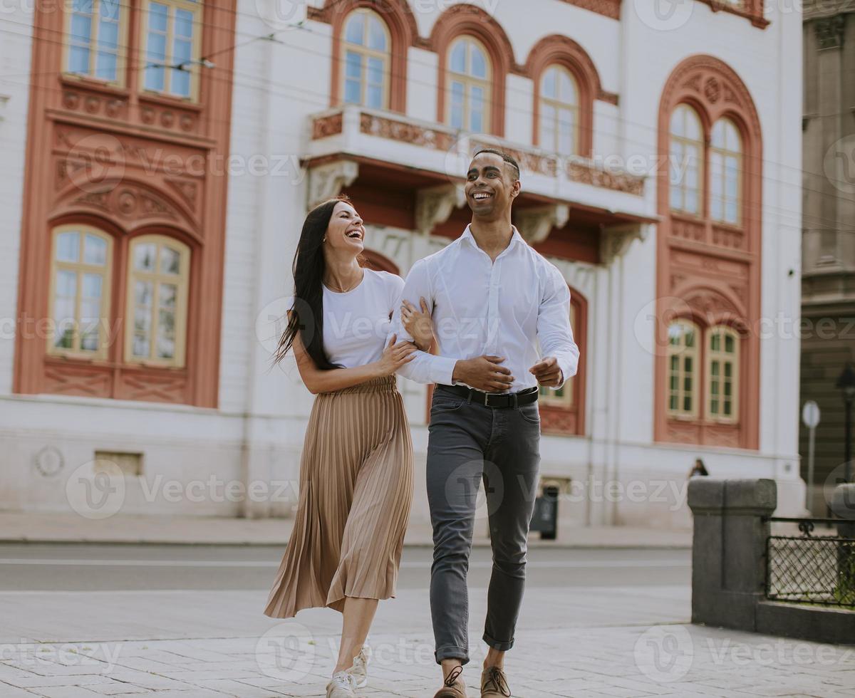 joven pareja multiétnica caminando por la calle foto