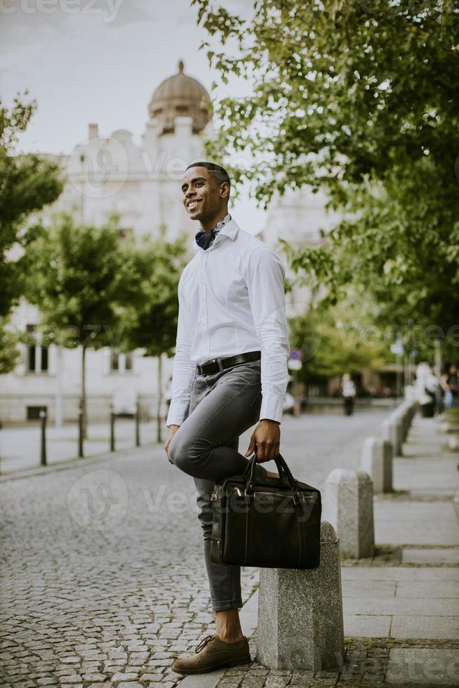 Young African American businessman waitng a taxi on a street photo