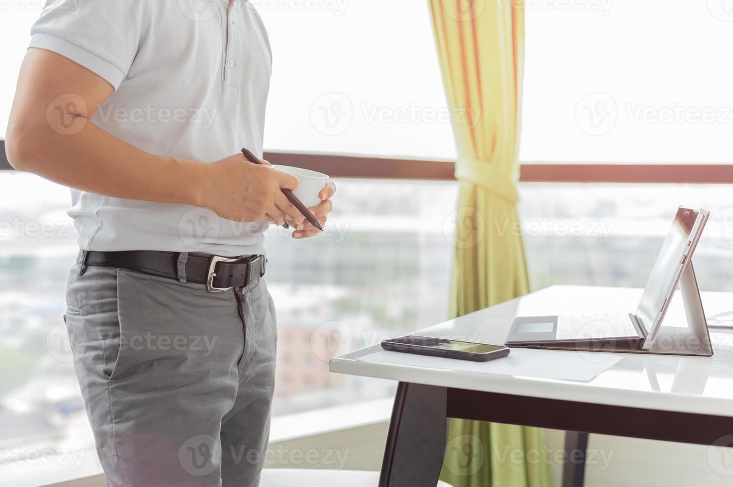 Businessman working laptop and holding cup coffee photo