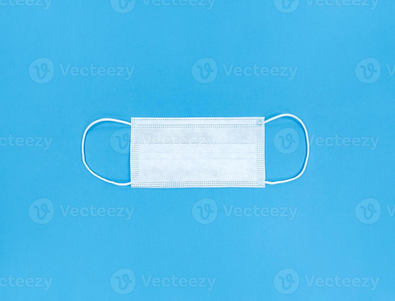 Medical disposable face mask on blue background photo