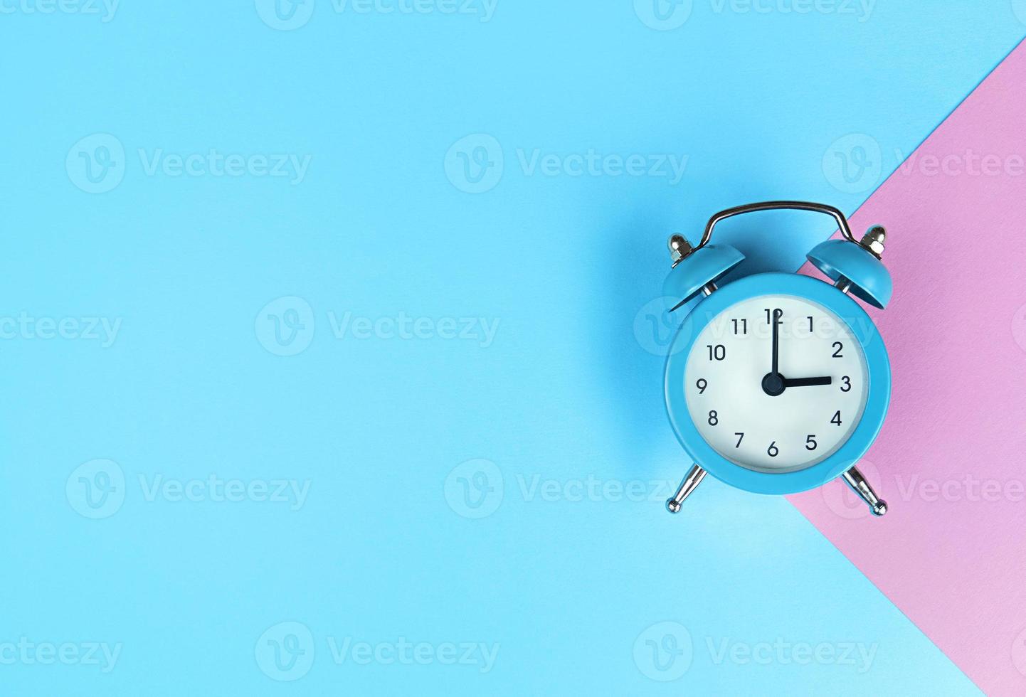 Retro alarm clock on blue background with copy space photo