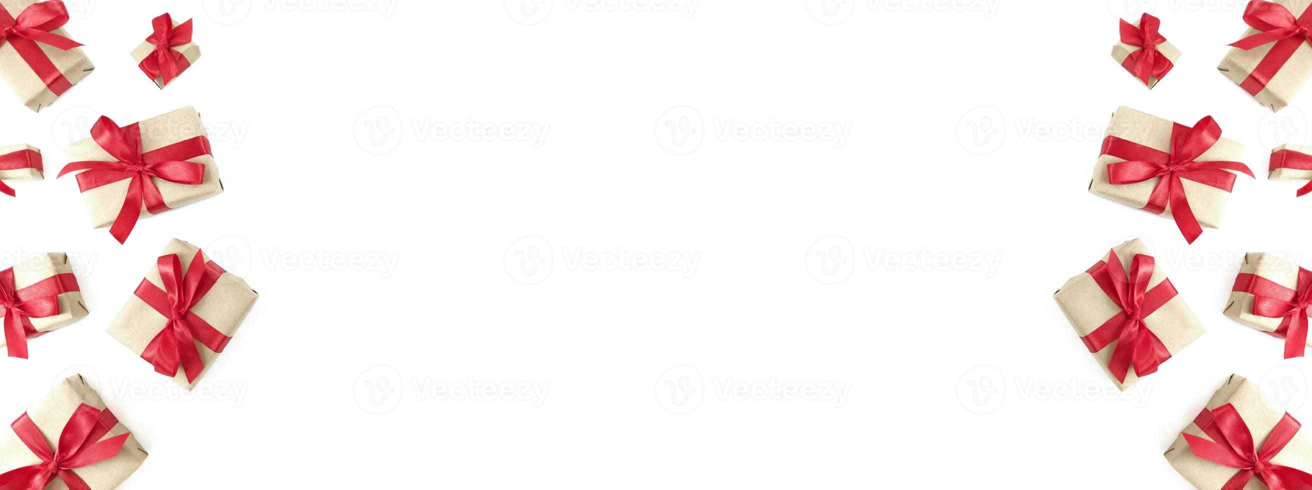 Gift boxes wrapped in craft paper with red ribbons and bows on a white background Festive wide banner copy space photo