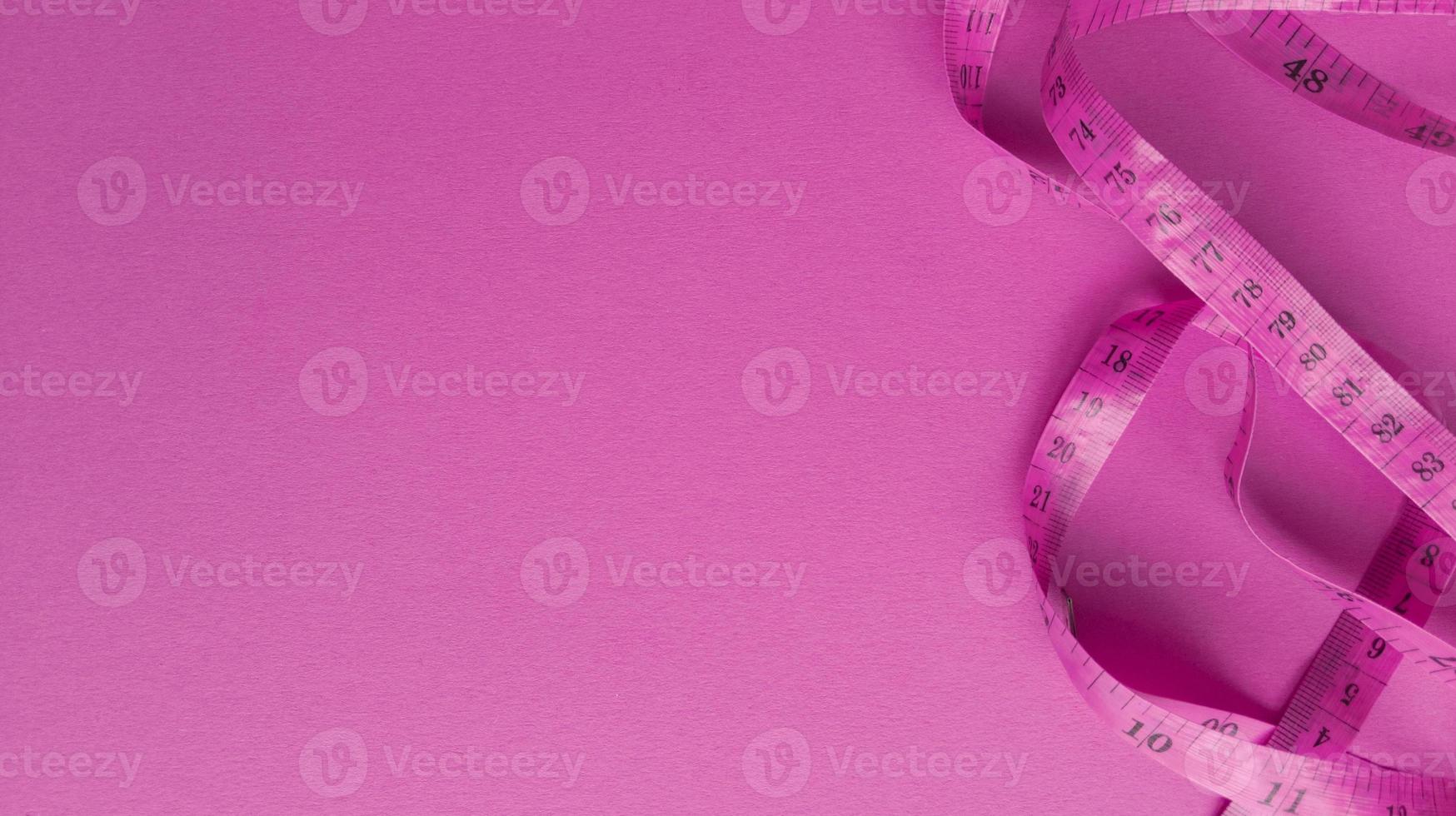 Pink centimeter on pink background Simple flat lay with pastel texture Fitness concept Stock photo