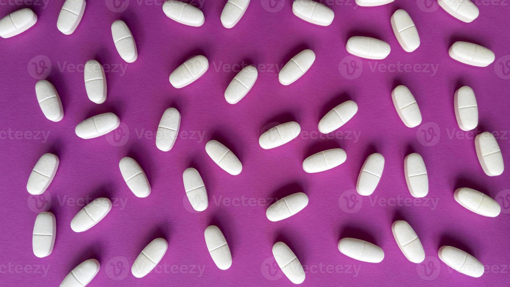 Tablets on pink background Simple flat lay with pastel texture Medical concept Stock photo