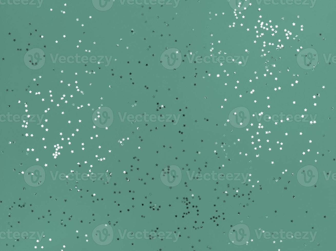 Confetti stars sparkling on a mint color background photo