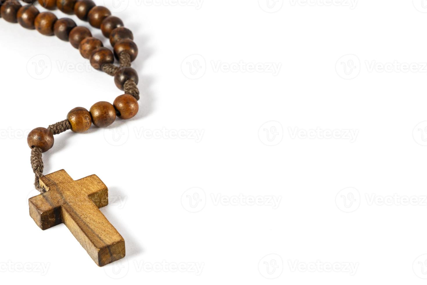 wood rosary with cross at left border and blank area at right side  white background photo