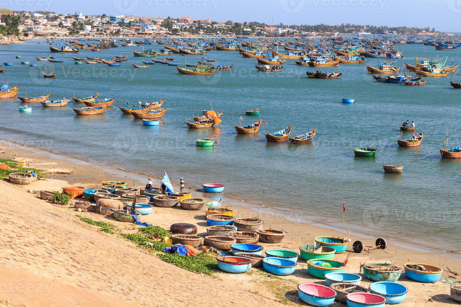 Pueblo de pescadores en la playa con abundante barco tradicional de Vietnam vietnamita foto