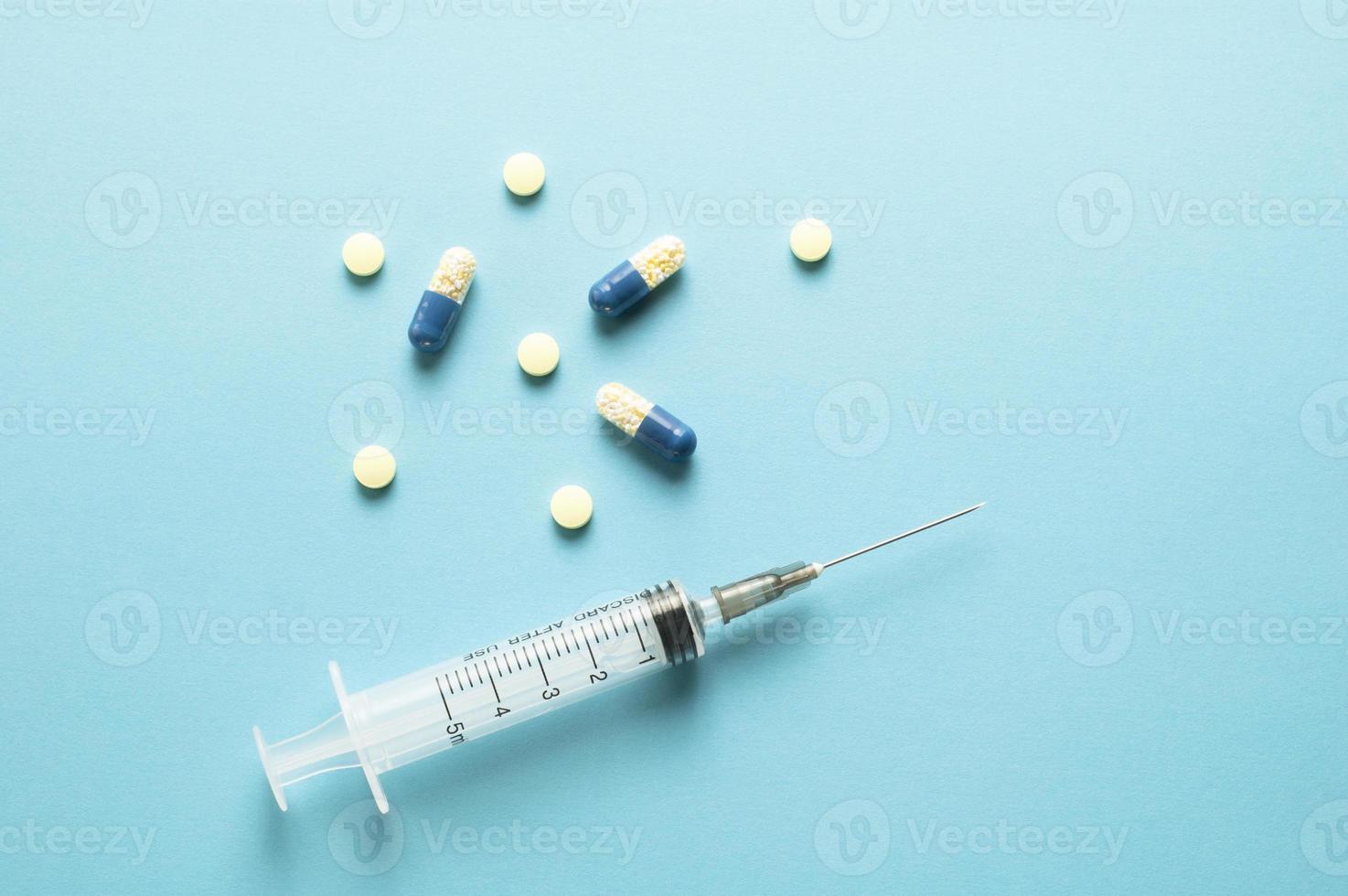 A syringe and drugs on blue background photo