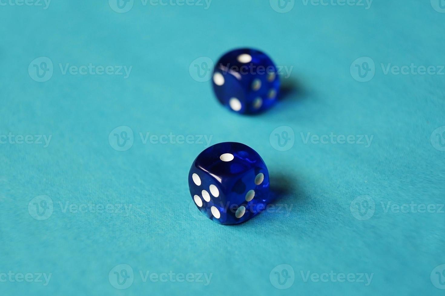 Una macro monocromática vibrante con profundidad de campo sobre dos dados de juego de vidrio azul con dos desafortunados número uno sobre fondo azul. foto