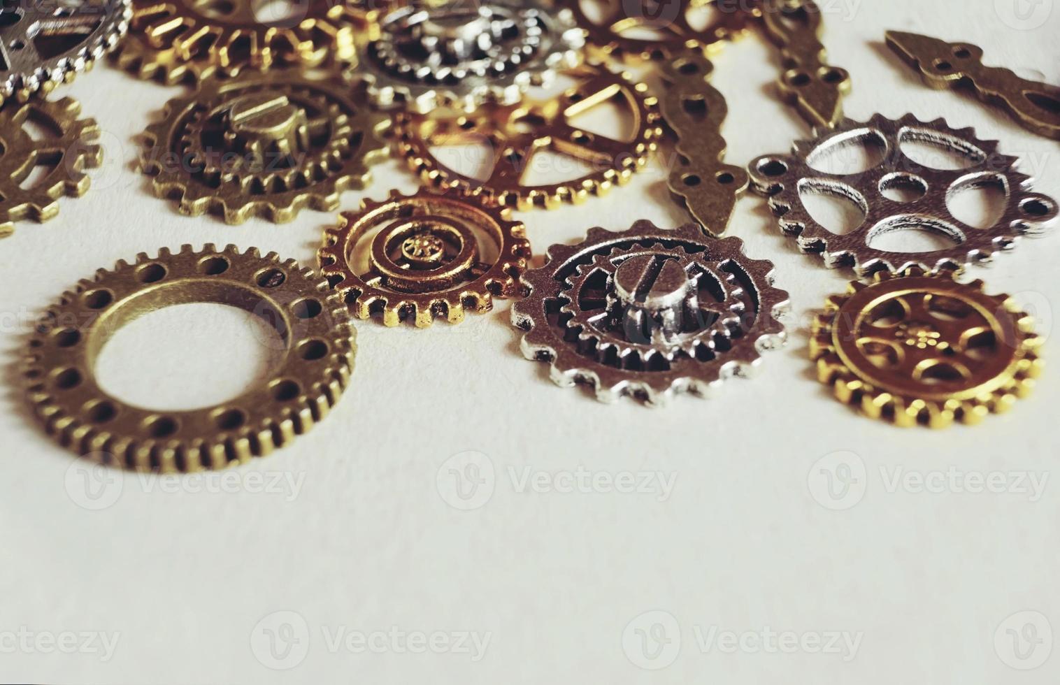 A steampunk and ancient macro about machinery made of bronze silver and gold gears with beige background photo