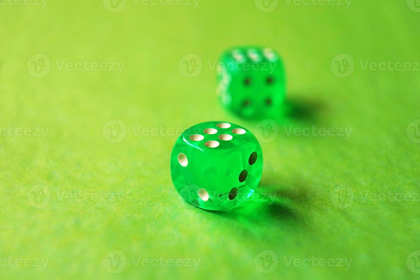 A vibrant monochromatic macro with depth of field about two green glass gambling dice with two lucky number six on green background photo