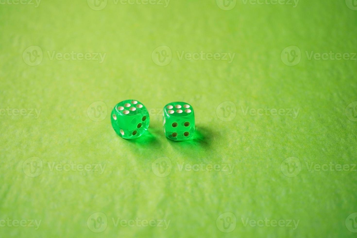 A vibrant monochromatic macro with depth of field about two green glass gambling dice with two lucky number six on green background photo