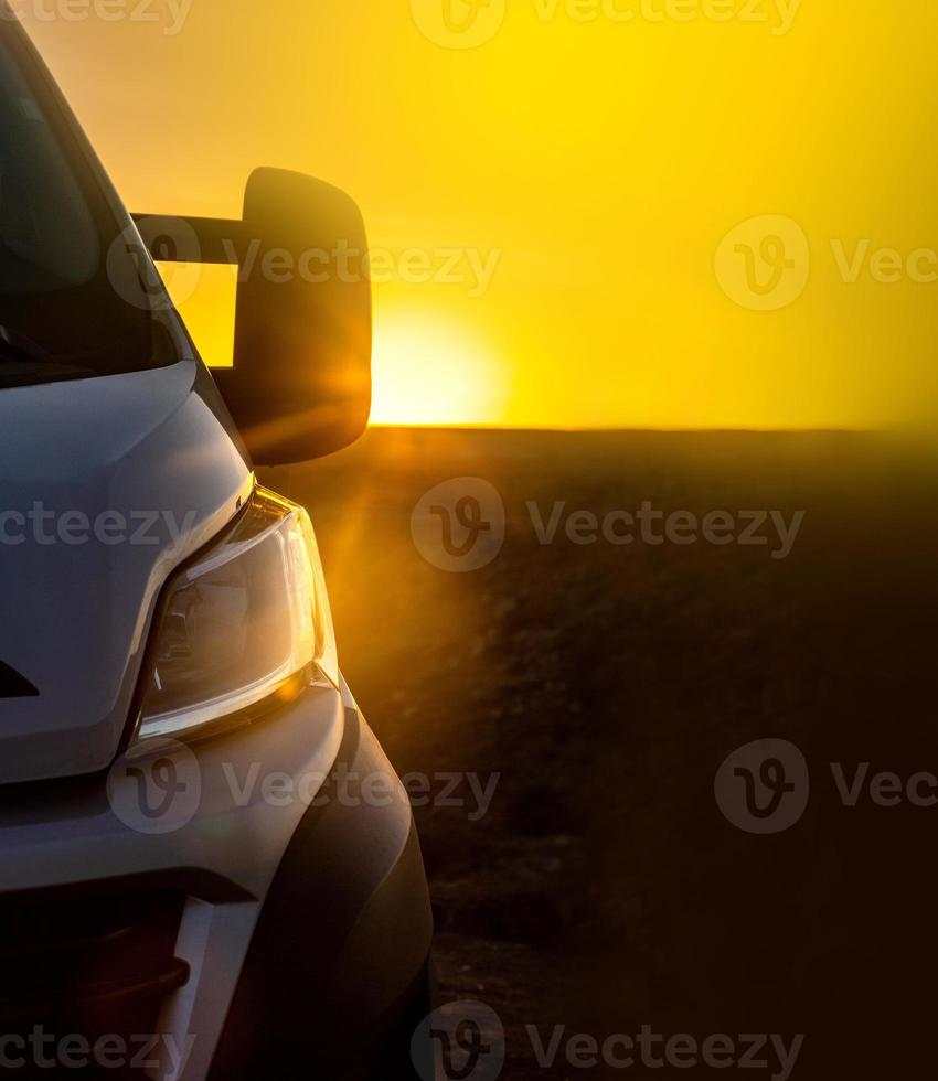 Fondo de puesta de sol con un coche, concepto de viaje por carretera foto