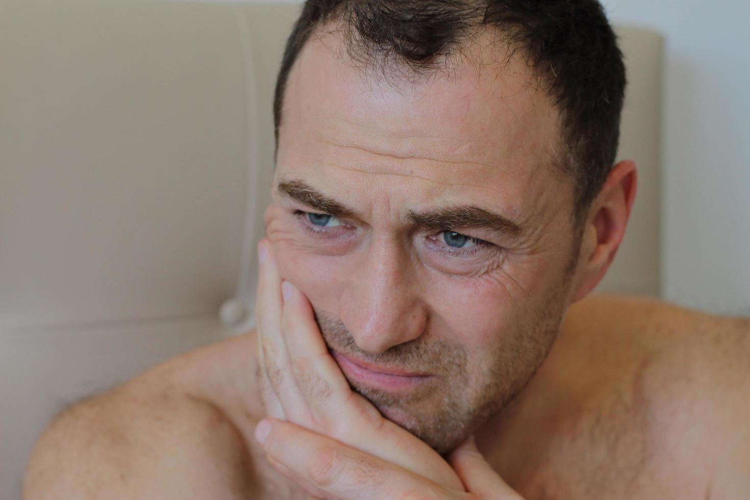 Man staying in bed with toothache photo